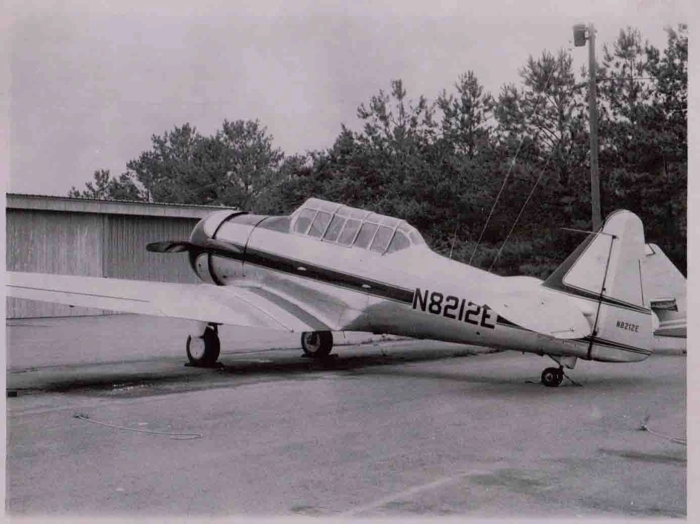 Vintage single-engine propeller airplane parked outside.