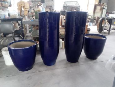 Four large blue ceramic pots of varying sizes.