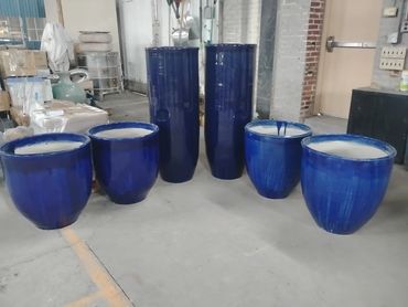 Blue ceramic pots of various sizes arranged indoors.