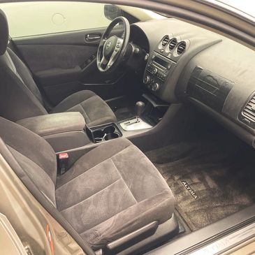Clean and spacious interior of a Nissan Altima with gray fabric seats.