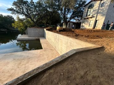 Construction site by a water body near a house.