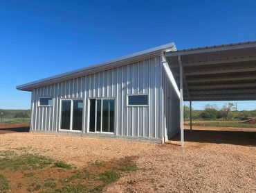 Modern metal-sided building under clear sky.