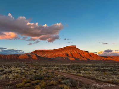 Sunset casts warm glow on red rock mesas on desert landscape, in LaVerkin Utah.