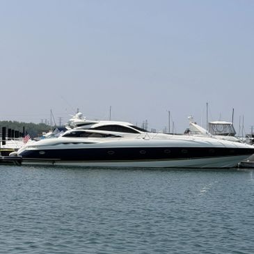 Luxury yacht docked at marina under clear sky.