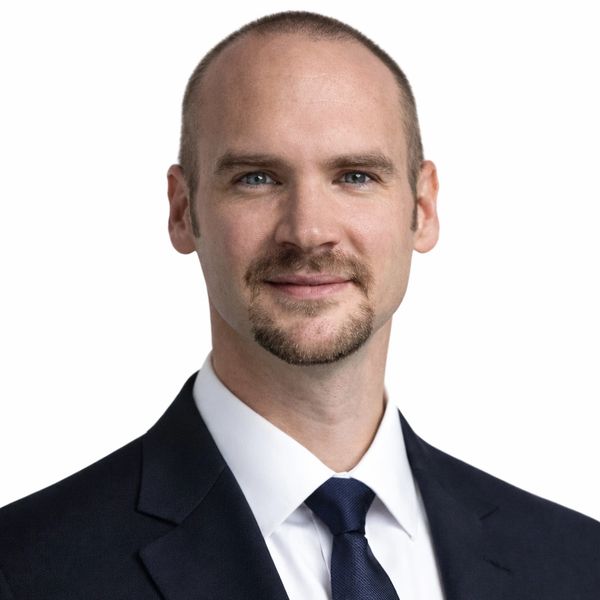 Professional headshot of a man in a suit and tie.