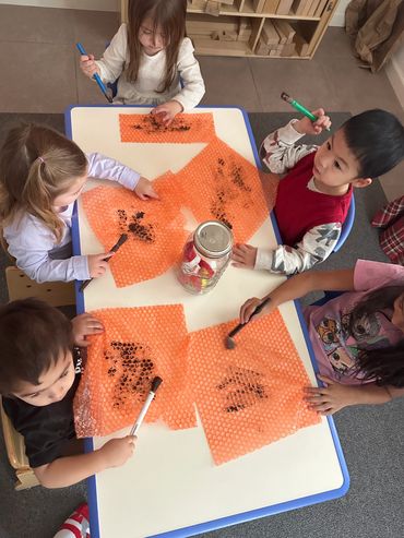 group of kids painting bubble wrap