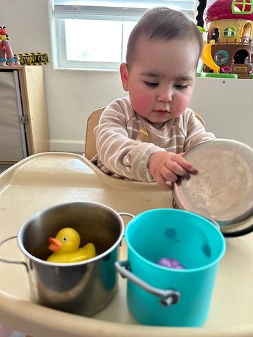 Infant playing with pots and pans