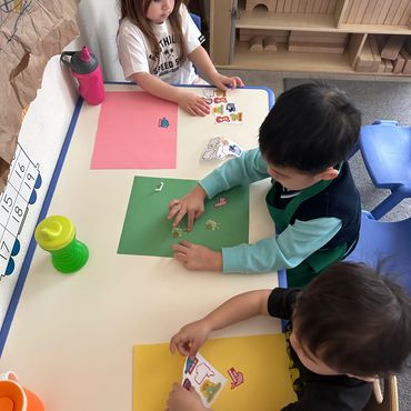 group of children placing stickers on paper
