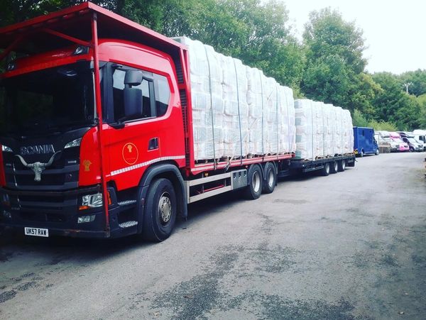 A truck transporting packed straw stacks