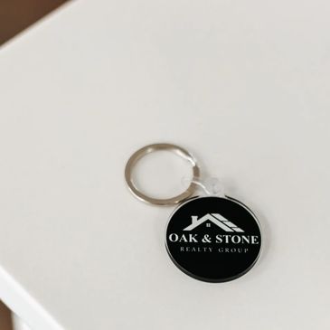 Oak & Stone Realty Group keychain resting on a modern kitchen countertop, symbolizing homeownership