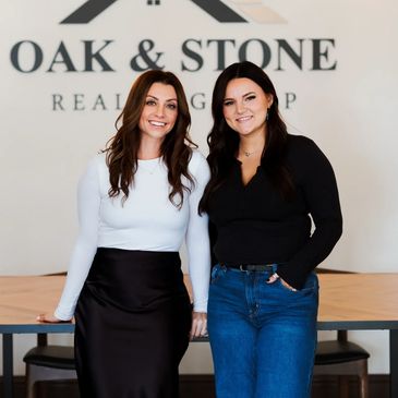 Oak & Stone  brokers posing in the office with a conference table and company logo in the background