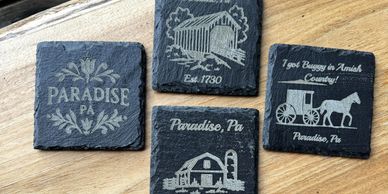 Set of four Paradise, PA themed coasters on wood.