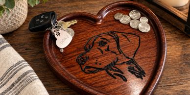 Heart-shaped wooden tray with dog sketch holding keys and coins.
