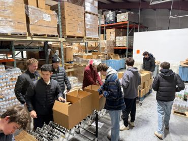 Volunteers packing boxes in a warehouse.