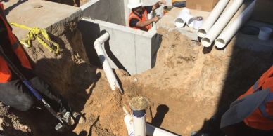 Construction workers installing underground pipes.