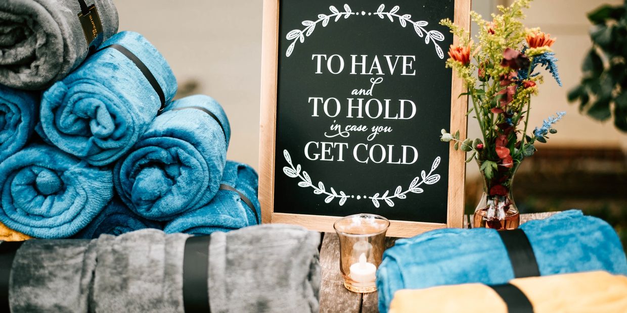 Blanket station with sign saying 'To have and to hold in case you get cold'.