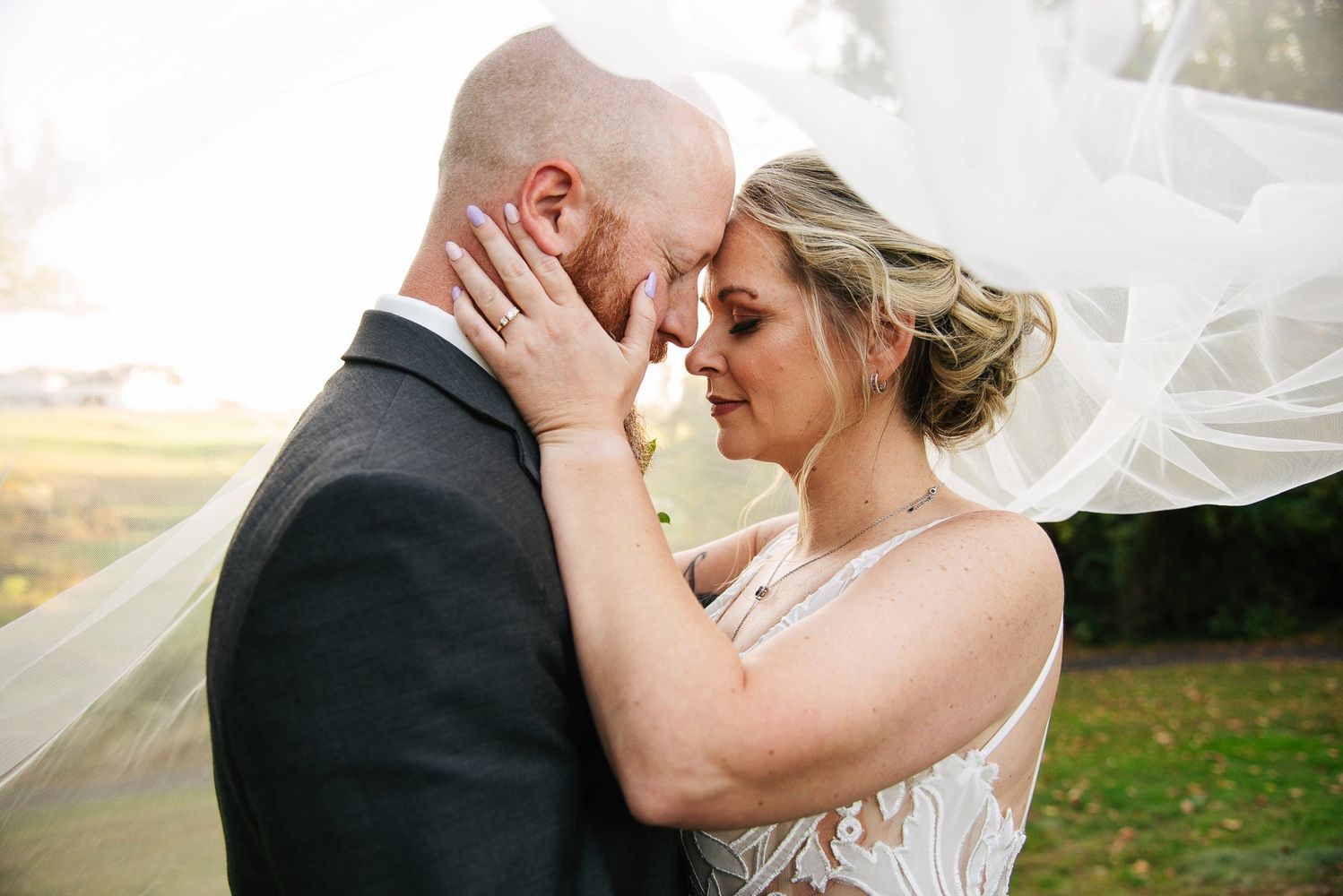 Bride and groom in Bucks County PA, share an intimate moment under the bride's veil at their wedding. Wedding Photography.