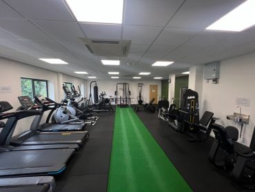 A clean and well-lit gym with various exercise machines.