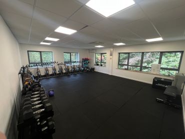 Well-equipped home gym with weights and exercise bikes.