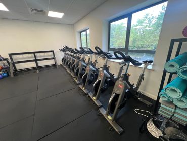 Indoor gym with exercise bikes and yoga mats.