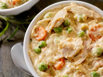 Crustless Chicken Pot Pie Bowl, Carrots, Peas, creamy, with a spoon on the side. 