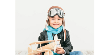 a little girl with an airplane toy and glasses 