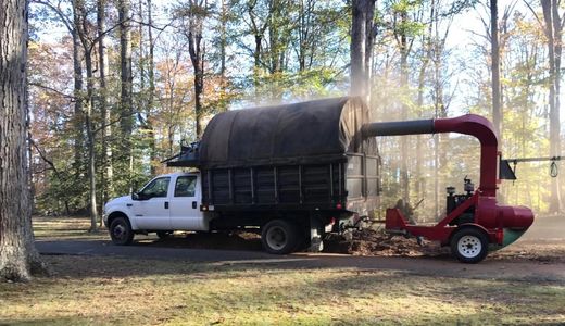 a truck pulling the equipment to clean the yard, do the lawn mowing and mulch 