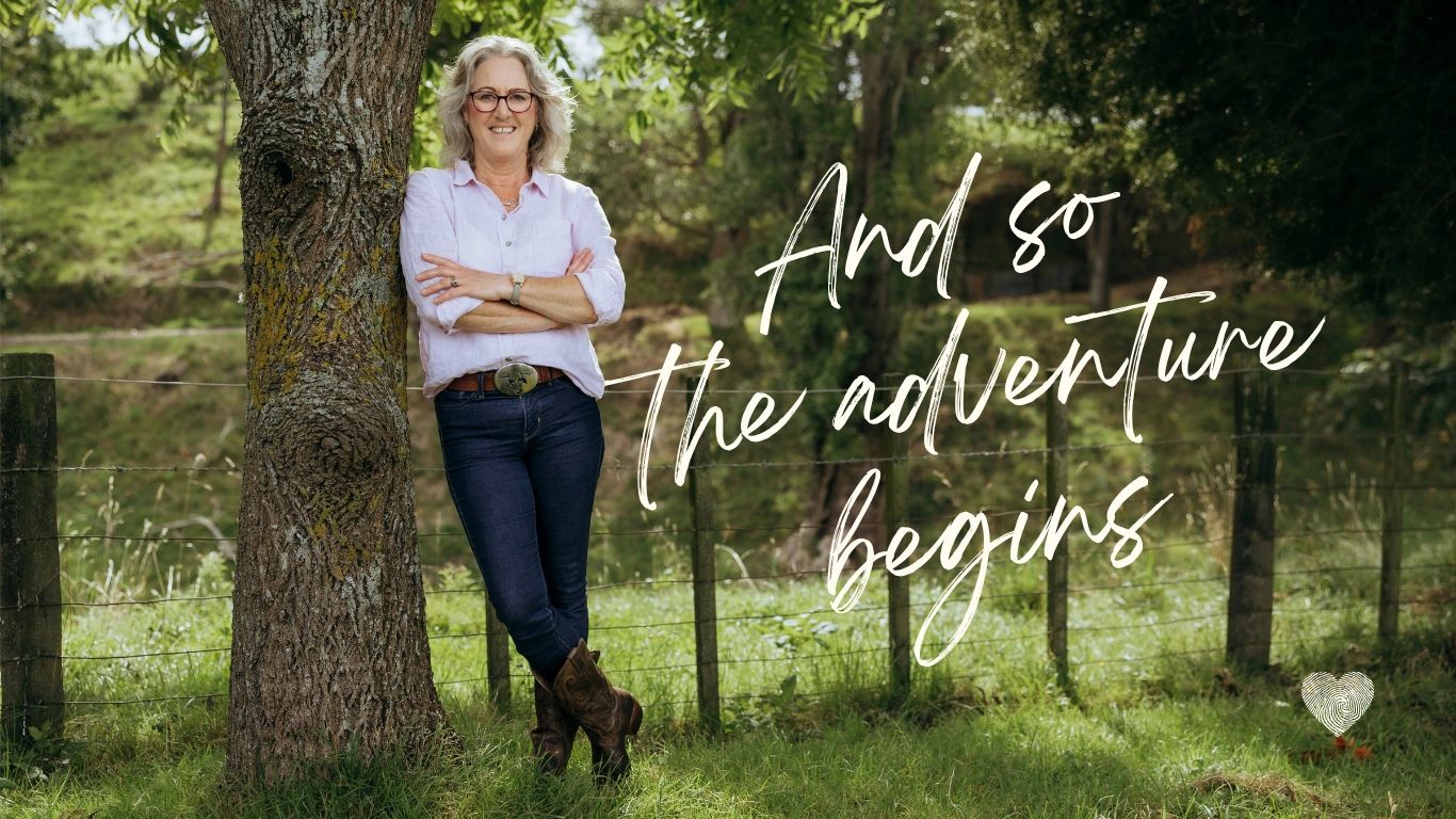 Smiling woman leaning on tree with the text 'And so the adventure begins'.