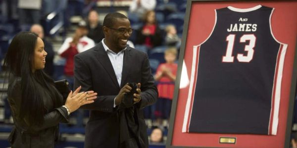 Two people unveil a framed jersey number 13.