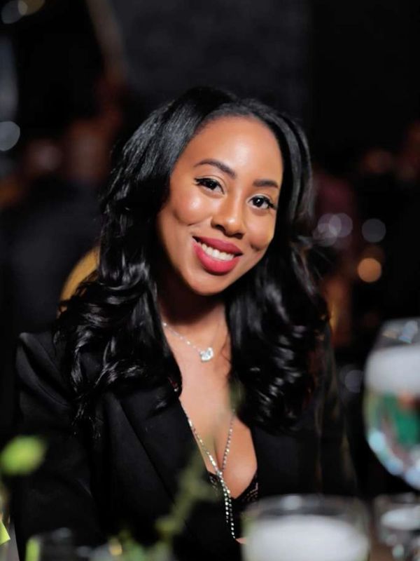 Smiling woman with long black hair at an event.