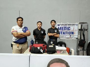 Three medics standing at a medic station with emergency bags.