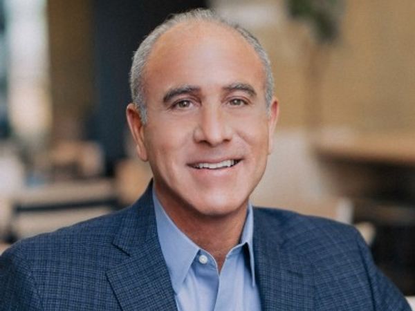 Smiling middle-aged man in a blue blazer and light blue shirt.