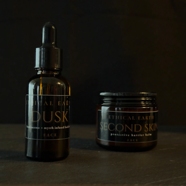 Ethical Earth Dusk face oil & Second Skin balm displayed on a dark surface with controlled lighting.