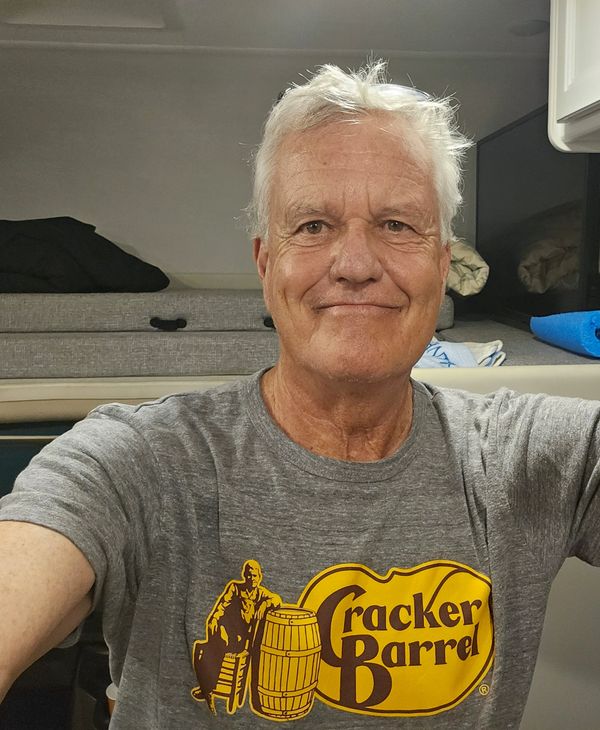 Smiling elderly man wearing a Cracker Barrel t-shirt.