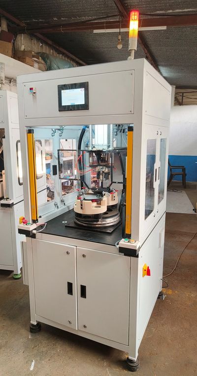 An industrial automation machine with safety features and a touchscreen interface.