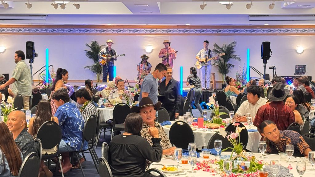 Band performing on stage at a lively banquet event with guests.