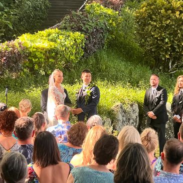 Outdoor wedding ceremony with bride, groom, and guests.