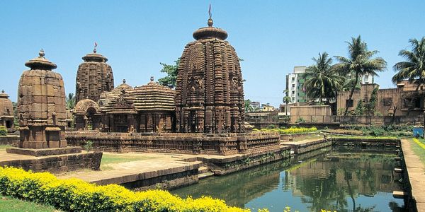 Ancient stone temple complex with a reflective water body and greenery.