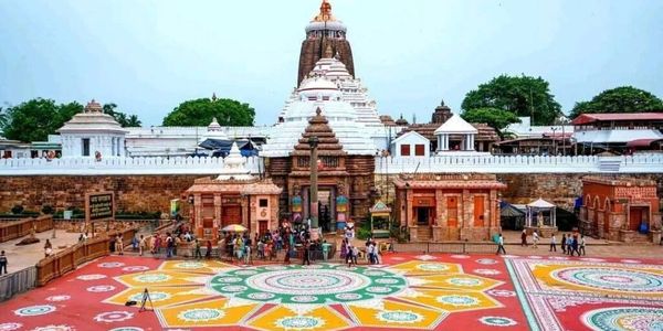 Jagannath Temple in Puri with colorful rangoli in front and visitors around.