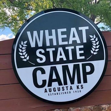 Round sign for Wheat State Camp in Augusta, Kansas.