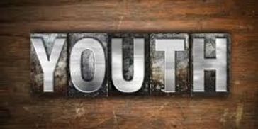 The word 'YOUTH' spelled out in metallic block letters on a wooden background.