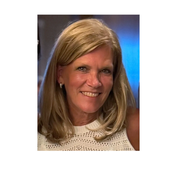 Smiling woman with blonde hair and a white knitted top.
