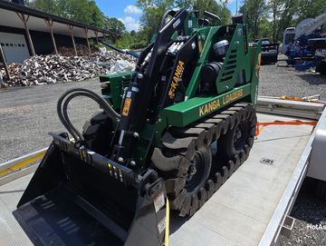 A compact green Kanga Loader on tracks.