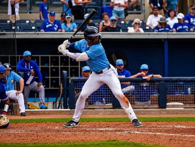 Baseball player at bat during a game with spectators in the background.