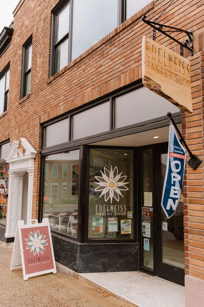 Exterior of Edelweiss Pastry Shop with signage and open flag.
