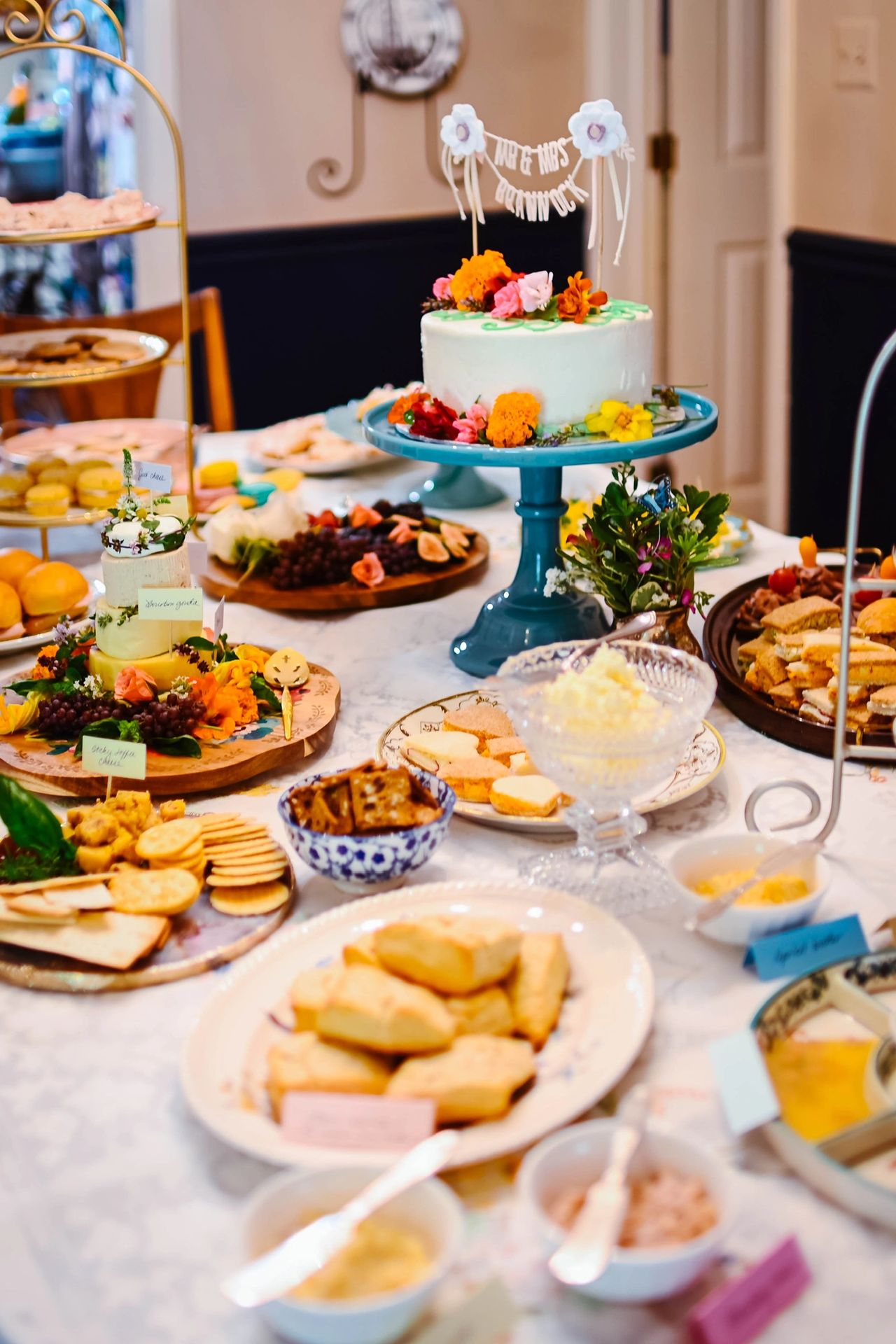 Table with pastel dishes and tea party food.