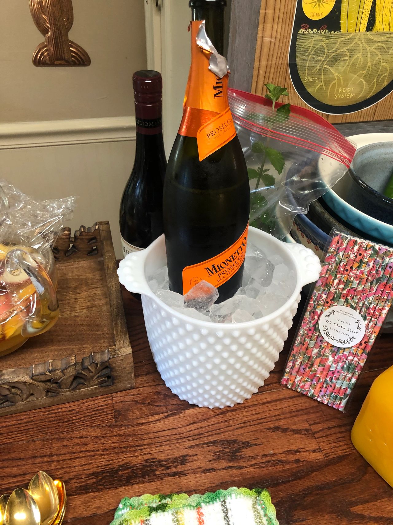 Bottle of Prosecco in white hobnail ice bucket.