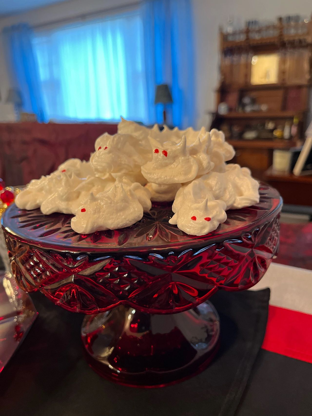 Meringue dragon cookies on red glass plate.