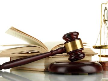 A judge's gavel, open law books, and scales of justice.