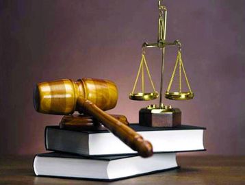 Judge's gavel and scales of justice on law books.